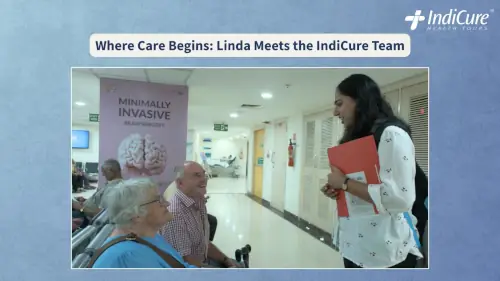 New Zealand patient Linda Davis and her husband Tony meeting an IndiCure health coordinator in a Mumbai hospital hallway.